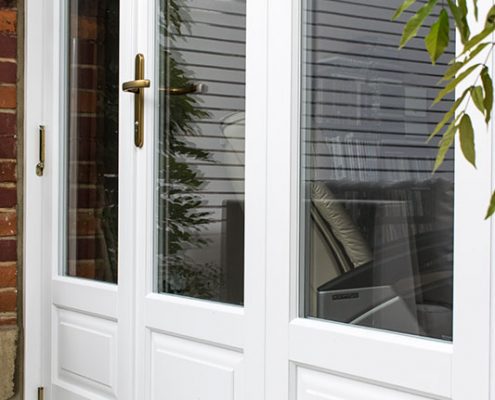 Timber white bifold door with brass hinges and lock