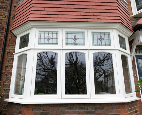 Timber bay window Timber bay window with stained glass fan lights